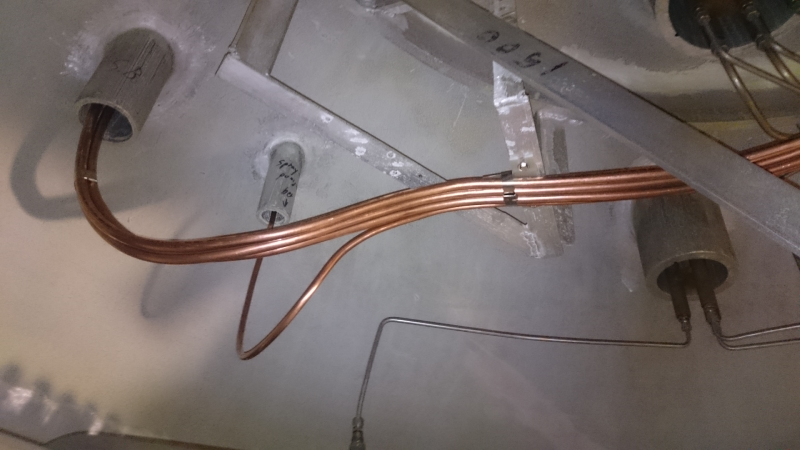 Industrial copper tubing installation routed through concrete conduits