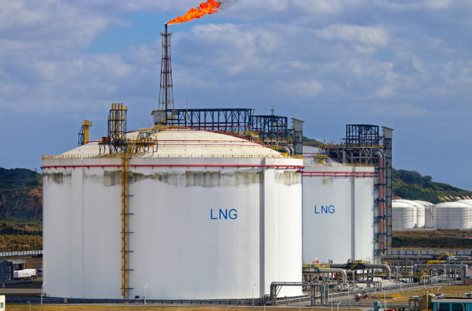 Large white LNG storage tanks at an industrial processing facility